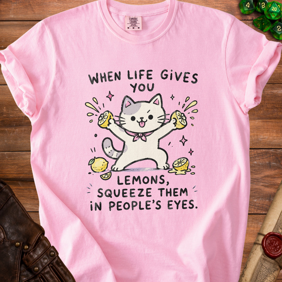 Pink t-shirt with cartoon cat squeezing lemons and text "When life gives you lemons, squeeze them in people's eyes."