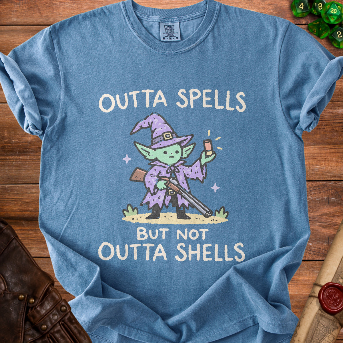 Blue t-shirt with a cartoon wizard holding a shotgun and the text "Outta Spells But Not Outta Shells".