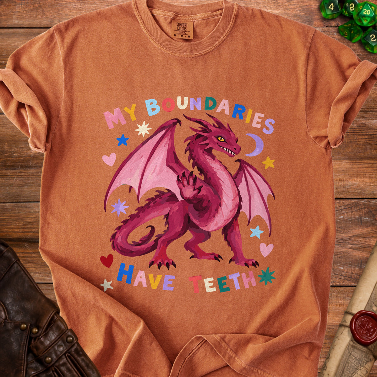 Orange t-shirt with a pink dragon and colorful text reading "MY BOUNDARIES HAVE TEETH".