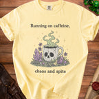 Yellow t-shirt with "Running on caffeine, chaos and spite" text and skull mug graphic.