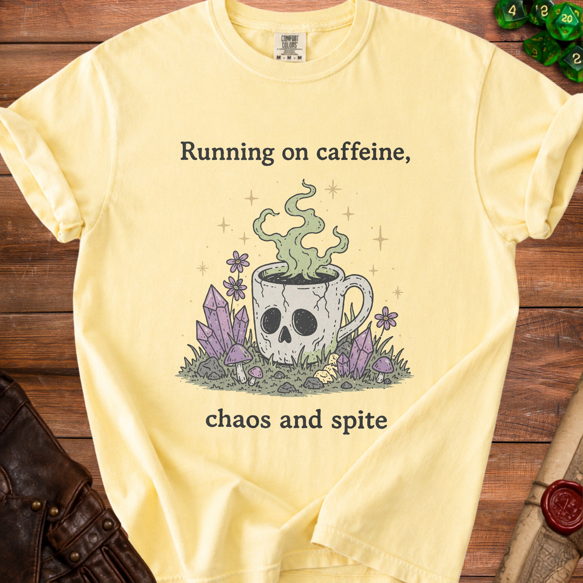 Yellow t-shirt with "Running on caffeine, chaos and spite" text and skull mug graphic.