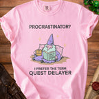 Pink t-shirt with text "PROCRASTINATOR? I PREFER THE TERM QUEST DELAYER" and cartoon wizard.