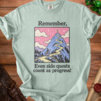 T-shirt with "Remember, Even side quests count as progress!" text and mountain graphic.