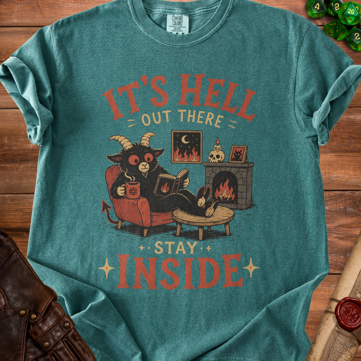 Black goat demon reads by fireplace with text "It's Hell Out There Stay Inside".