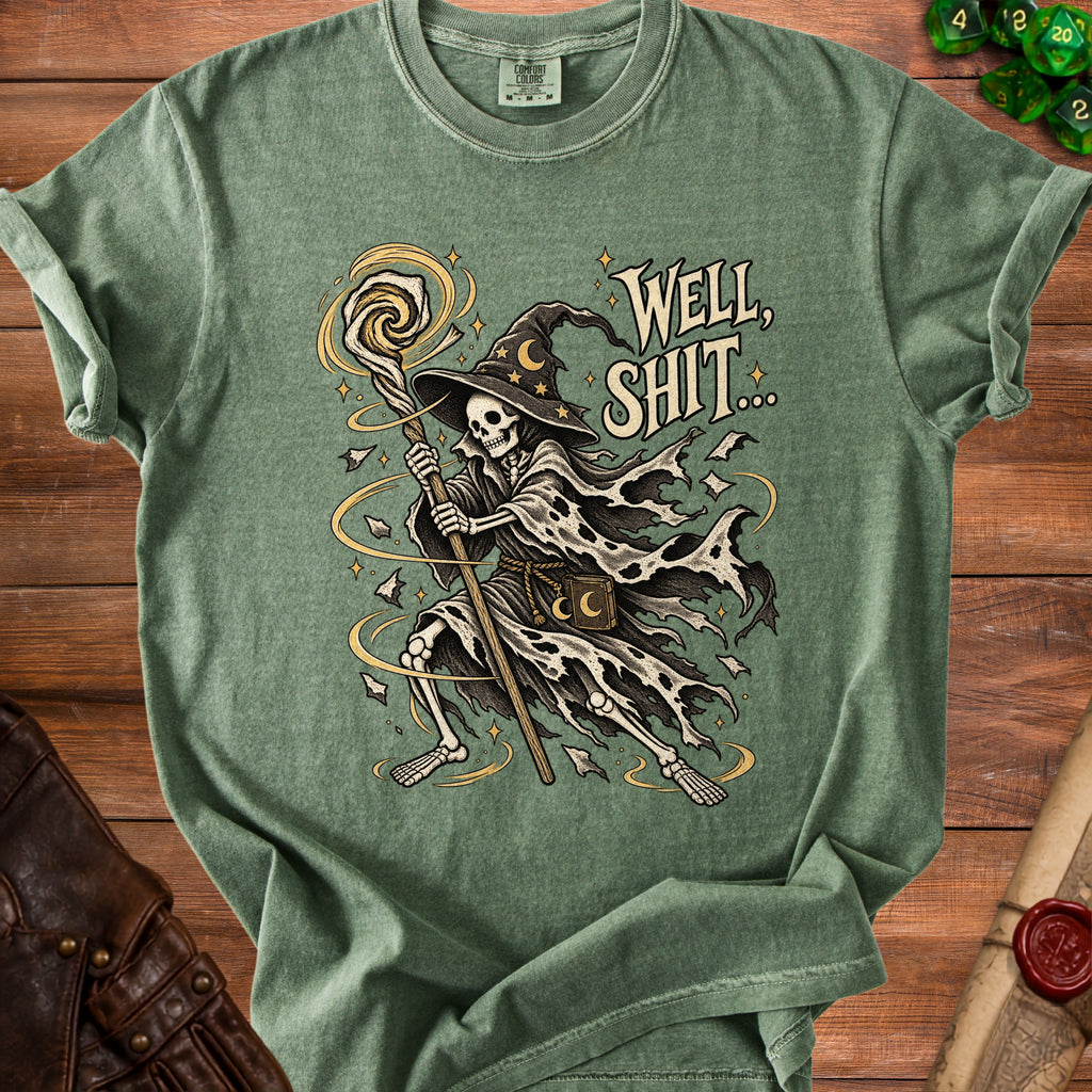 Skeleton wizard graphic with text "Well, Shit..." on a green t-shirt.
