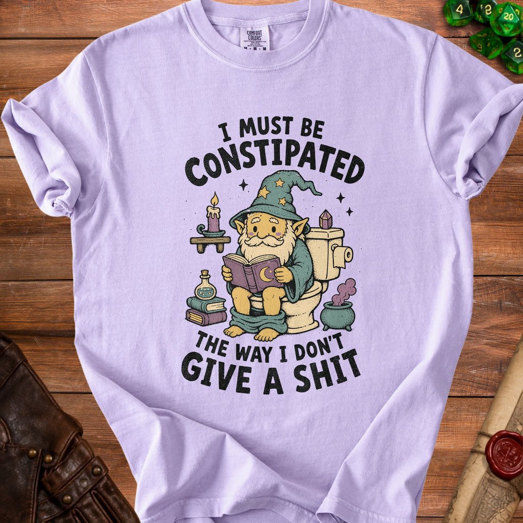 Light purple t-shirt with illustration of a gnome reading on a toilet, text "I must be Constipated The Way I Don't Give a Shit".