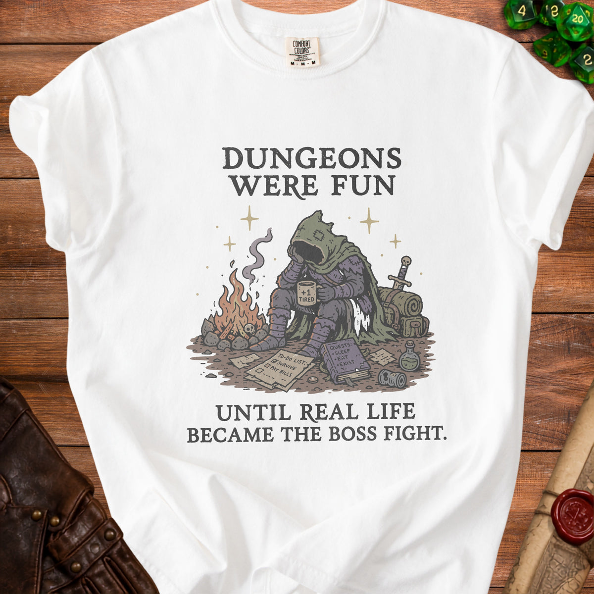 White t-shirt with graphic of tired adventurer and text "Dungeons Were Fun Until Real Life Became The Boss Fight."