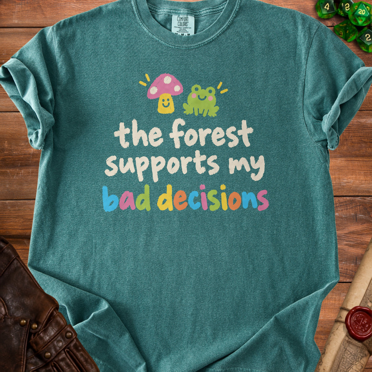 Teal t-shirt with frog, mushroom, and text: "the forest supports my bad decisions".