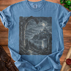 Blue t-shirt with a print of a cloaked figure walking towards a moonlit castle.