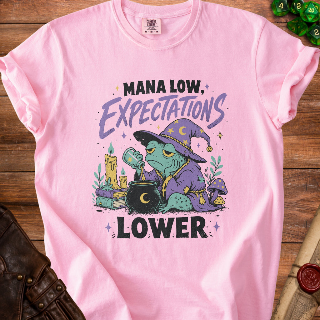 Pink t-shirt with a frog wizard pouring potion, "Mana Low, Expectations Lower" text.