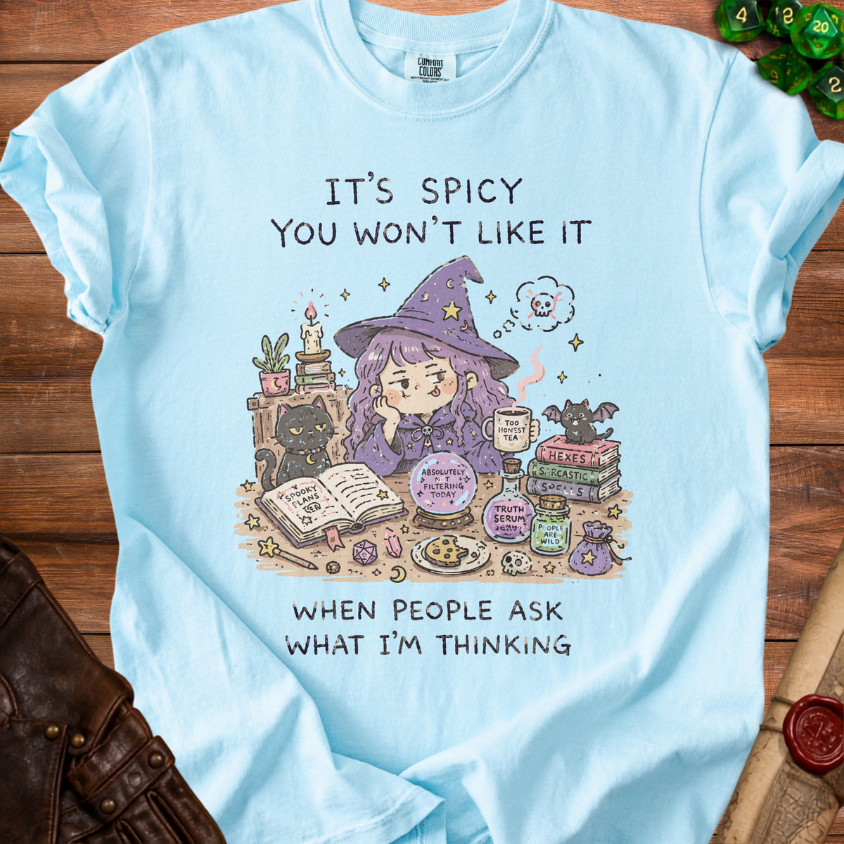 Light blue t-shirt with illustration of a witch and text: "It's Spicy You Won't Like It When People Ask What I'm Thinking".