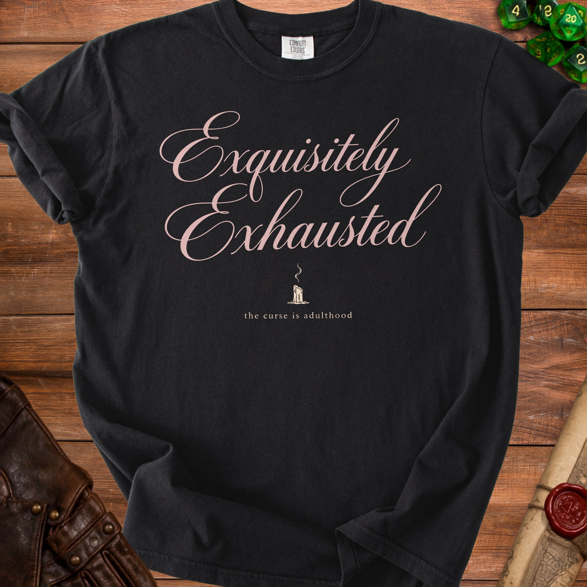Black t-shirt with pink script text "Exquisitely Exhausted" and a candle graphic.