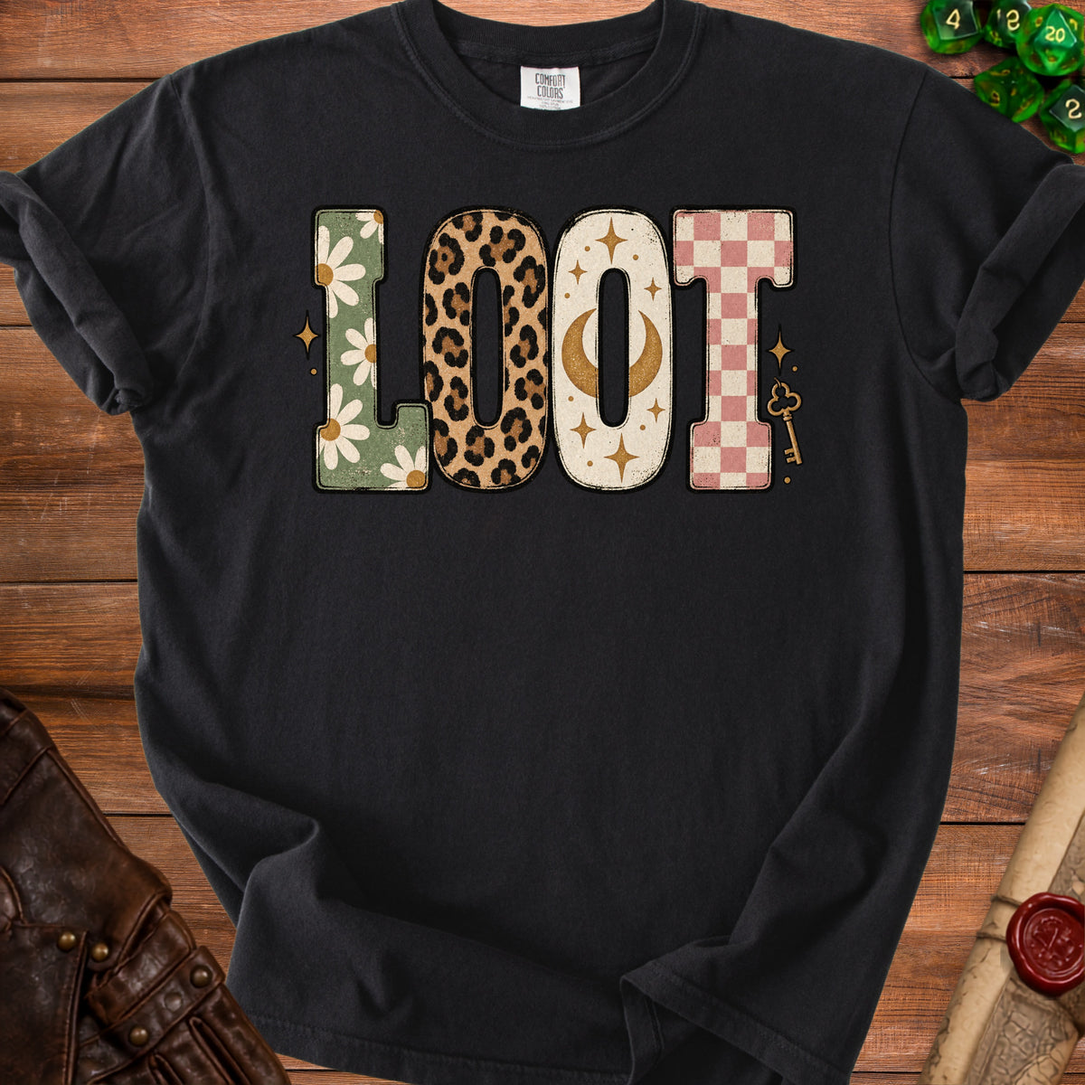 Black t-shirt with "LOOT" graphic featuring daisies, leopard print, moon, and checkerboard patterns.