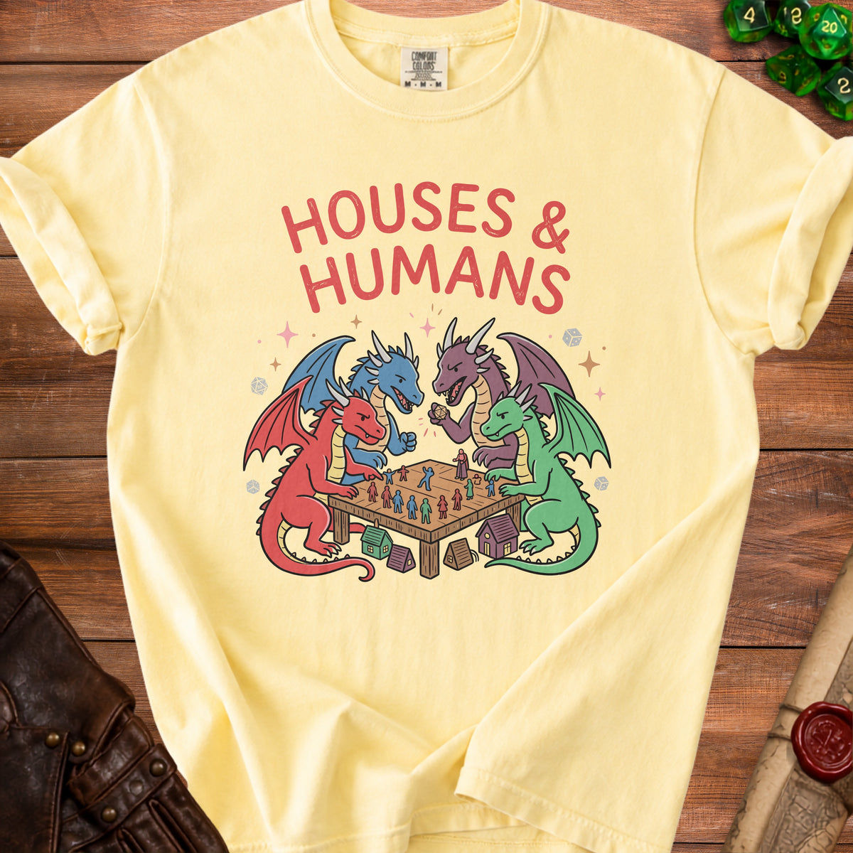 Yellow t-shirt with "HOUSES & HUMANS" text and dragons playing a board game.