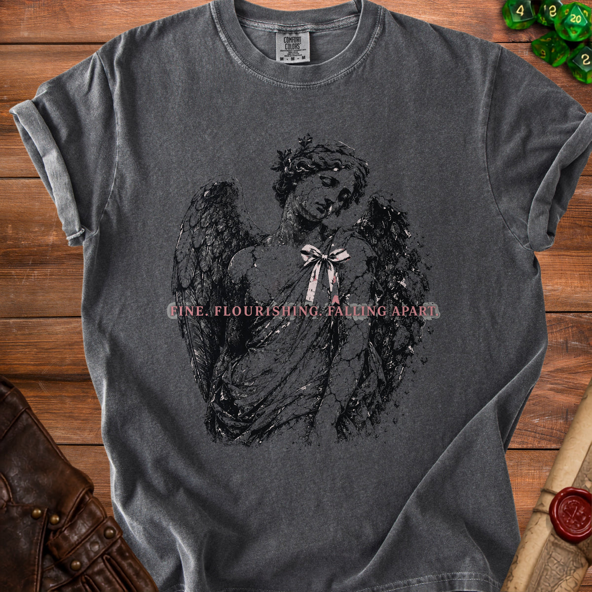 Dark gray t-shirt with cracked angel graphic and text "fine. flourishing. falling apart."