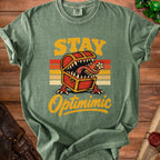 T-shirt with "STAY Optimimic" text and a monster chest graphic.