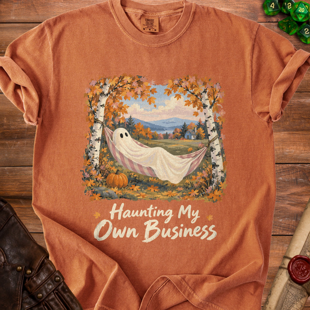 Orange t-shirt with a ghost in a hammock and text "Haunting My Own Business."