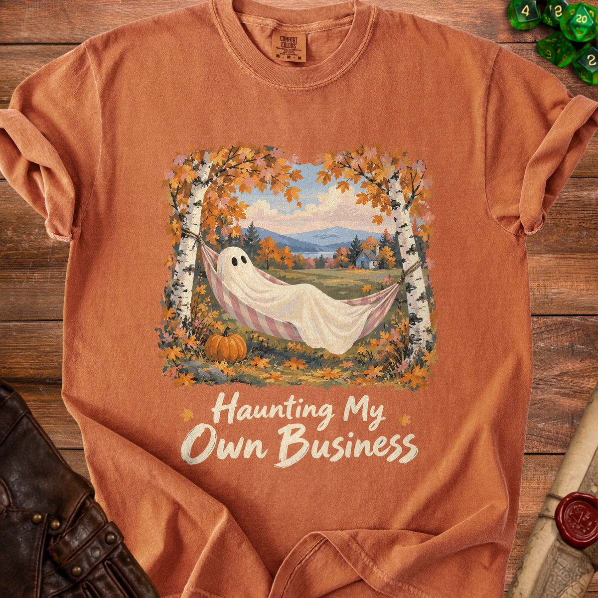 Orange t-shirt with a ghost in a hammock and text "Haunting My Own Business."