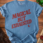 Blue t-shirt with "MAGICAL BUT EXHAUSTED" text and moon and star graphic.