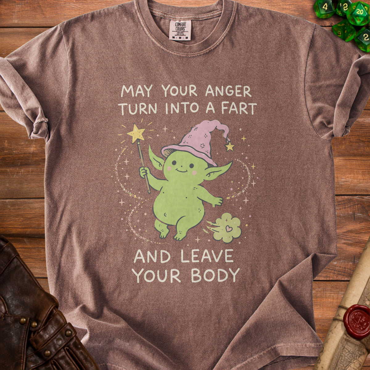 Brown t-shirt with a green goblin character casting a fart with text "MAY YOUR ANGER TURN INTO A FART AND LEAVE YOUR BODY".
