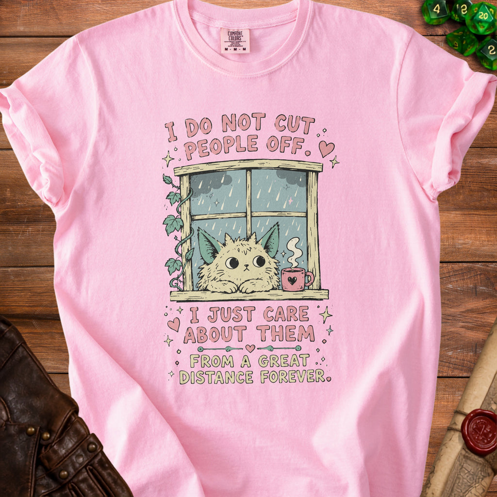 Pink t-shirt with a graphic of a cat looking out a rainy window and the text "I do not cut people off. I just care about them from a great distance forever."