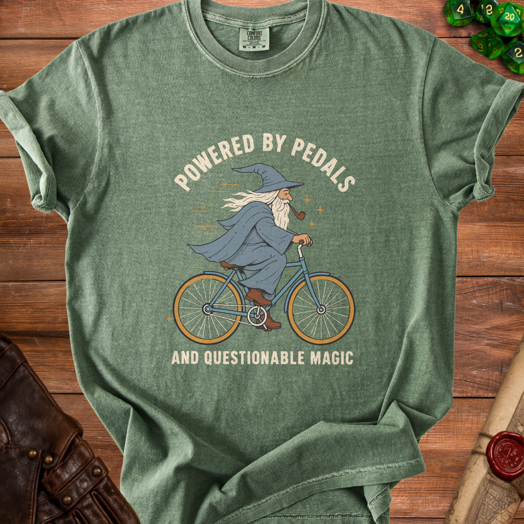 Green t-shirt with a wizard riding a bicycle and text "POWERED BY PEDALS AND QUESTIONABLE MAGIC".