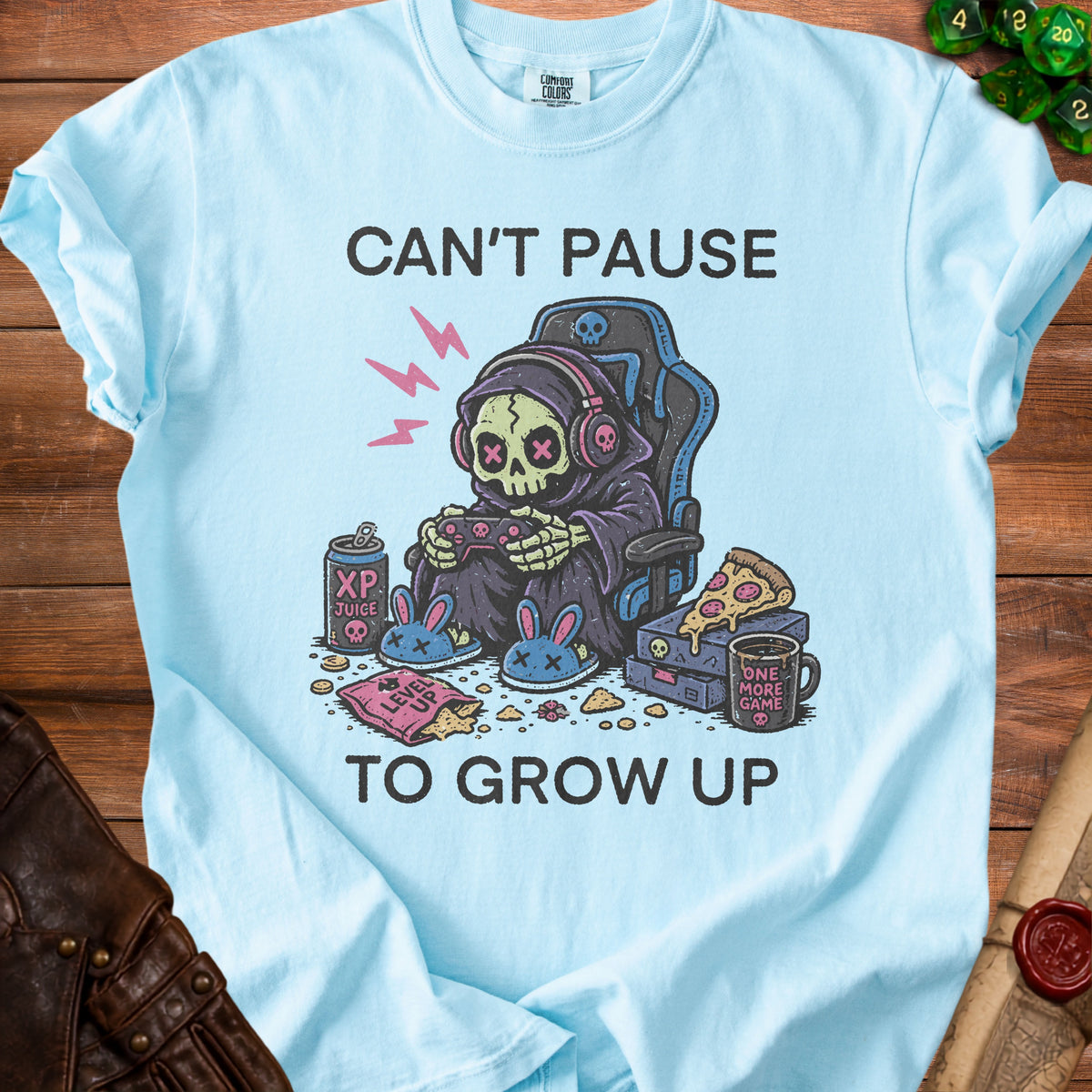 Light blue t-shirt with "Can't Pause To Grow Up" text and Grim Reaper gaming graphic.