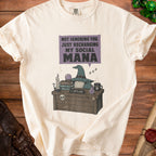 Cream t-shirt with "Not Ignoring You, Just Recharging My Social Mana" graphic.