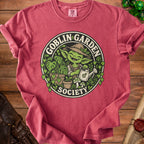 Goblin Garden Society logo on a red t-shirt with a gardening goblin.