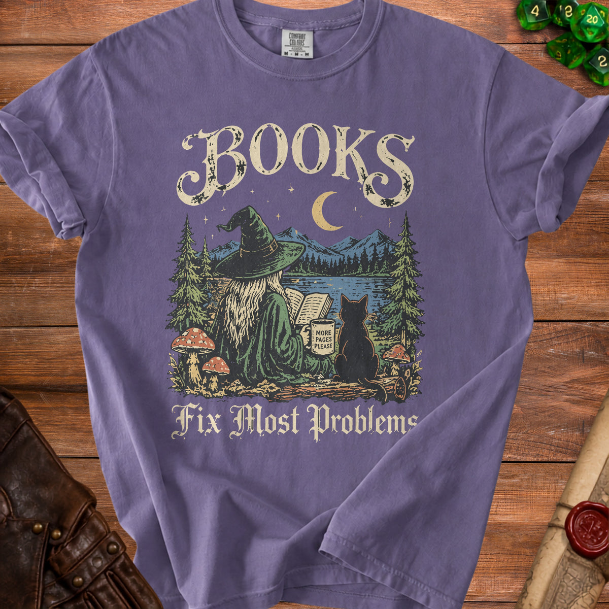Purple t-shirt graphic of witch reading with cat, mountains, and moon. Text: "BOOKS Fix Most Problems"