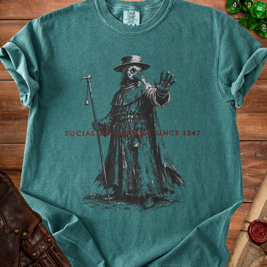 Plague doctor graphic with text "SOCIAL DISTANCING SINCE 1347" on teal shirt.