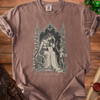 Brown t-shirt with a gothic illustration of a demon reading a scroll.