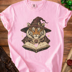 Pink t-shirt with tiger wizard design, open book, and d20 dice.