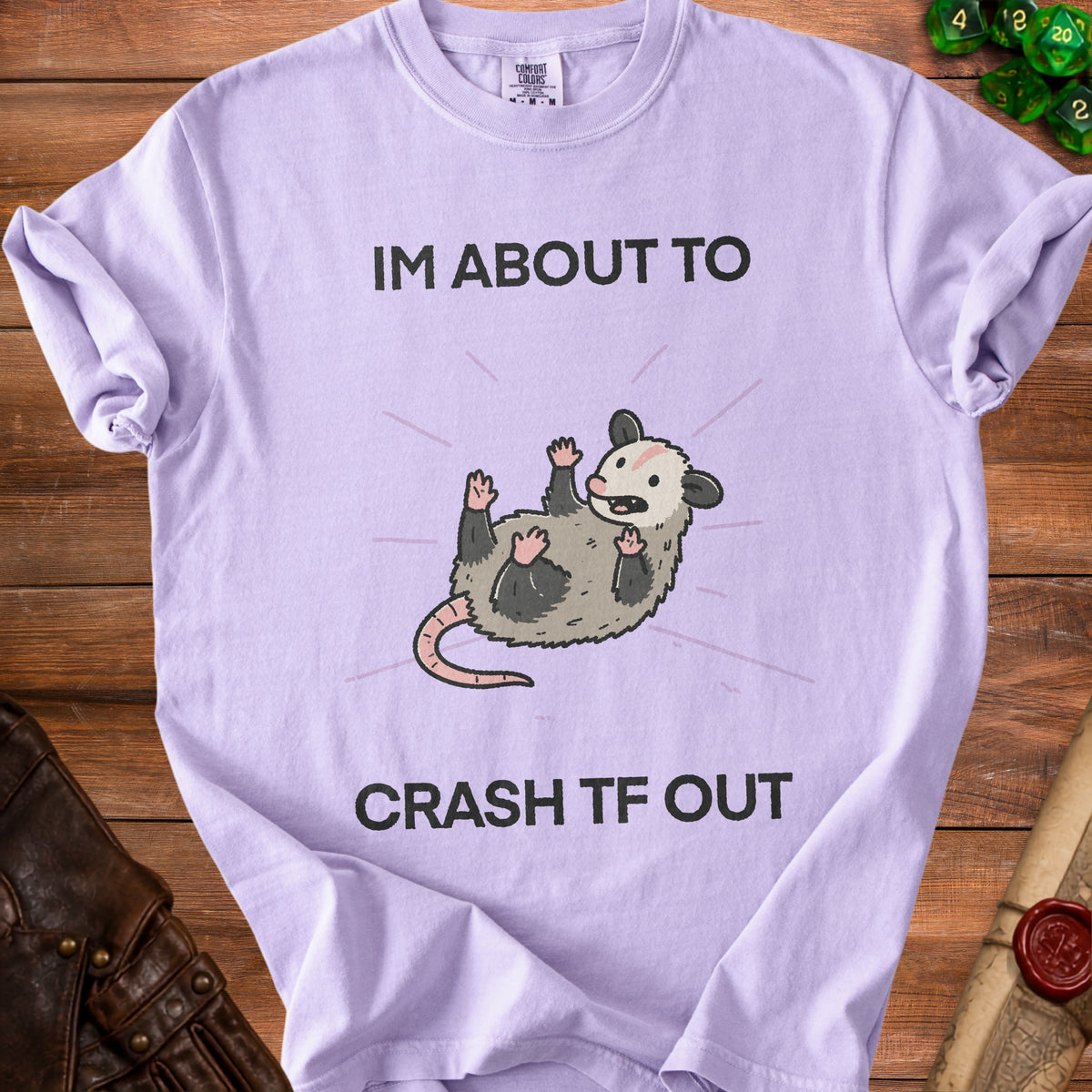 Purple t-shirt with a graphic of an opossum and text "IM ABOUT TO CRASH TF OUT."