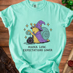 Aqua t-shirt with wizard snail graphic and "MANA LOW, EXPECTATIONS LOWER" text.