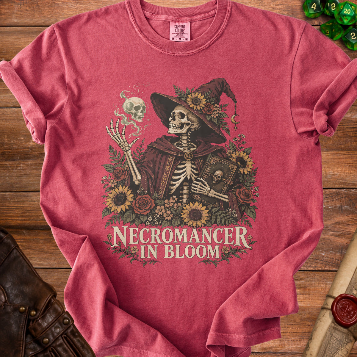 Skeleton necromancer in hat surrounded by flowers with text "NECROMANCER IN BLOOM".
