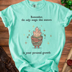 Teal t-shirt with crystals in a pot, text reads "Remember, the only magic that matters is your personal growth".