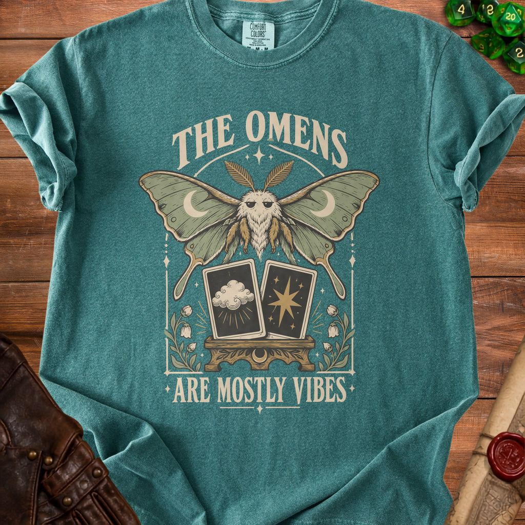Teal t-shirt with moth, tarot cards, and text "The Omens Are Mostly Vibes".