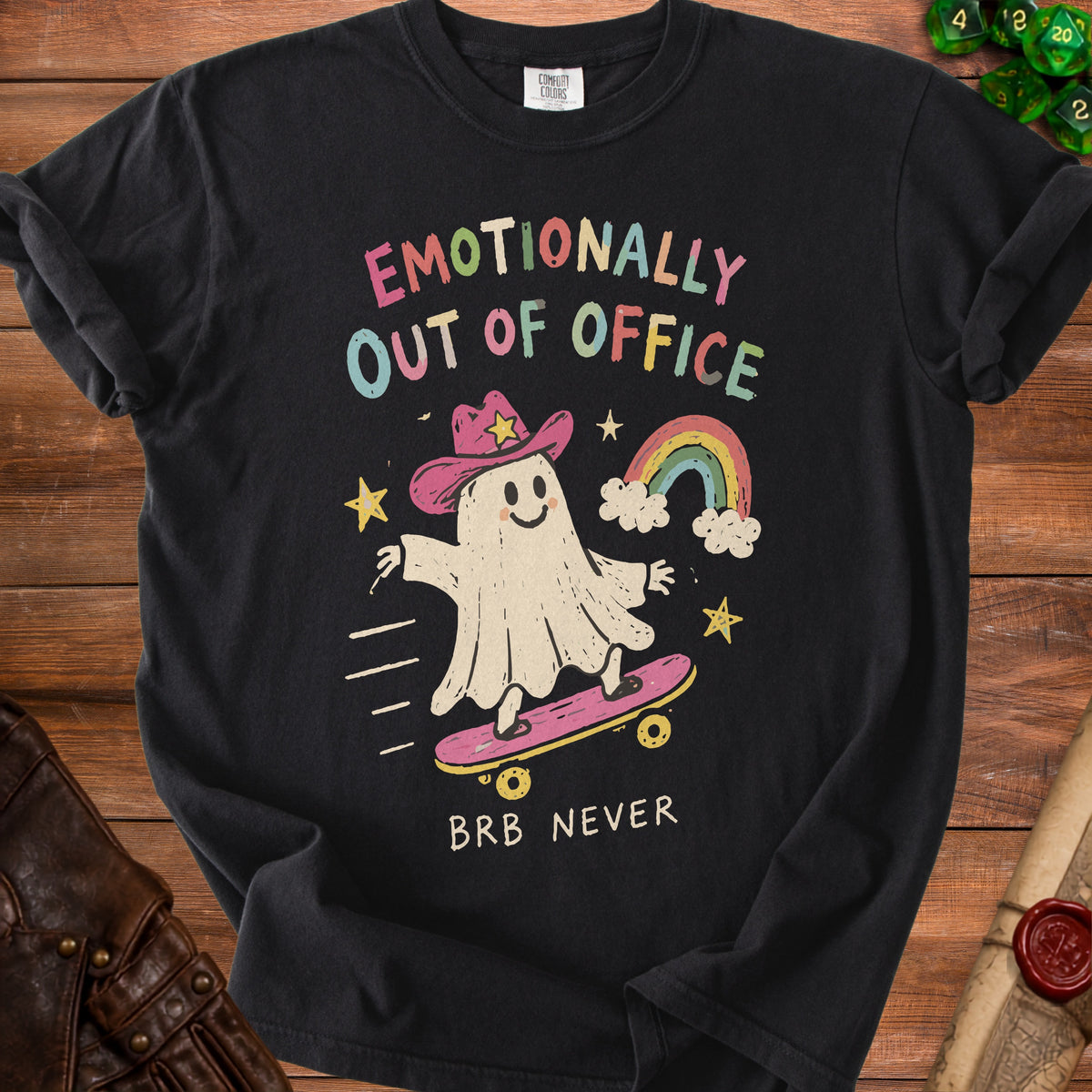 Black t-shirt with a ghost wearing a cowboy hat on a skateboard, text "EMOTIONALLY OUT OF OFFICE BRB NEVER".