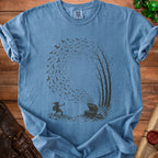 Blue t-shirt with dark graphic of a creature, treasure chest, bats, and trees.