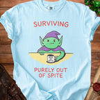 Light blue t-shirt with green goblin character and text "SURVIVING PURELY OUT OF SPITE".