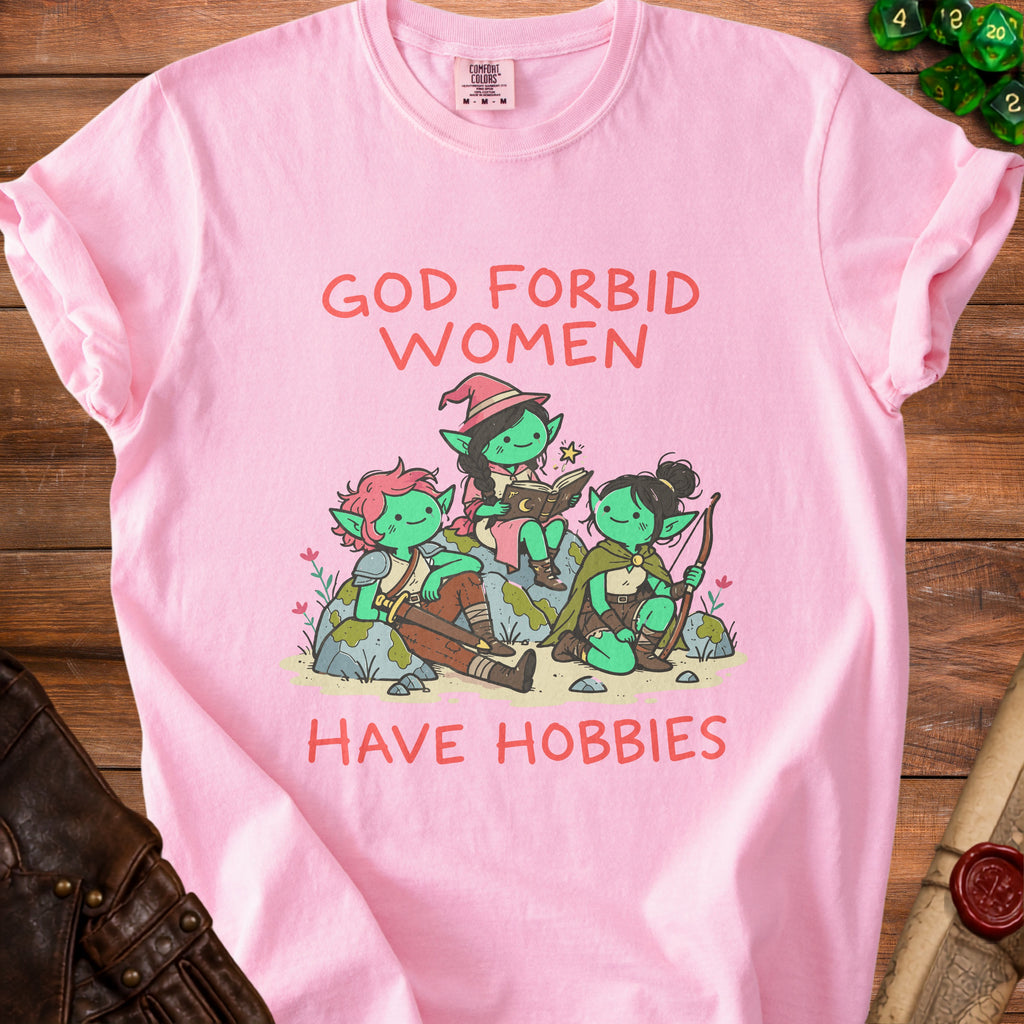 Pink t-shirt with "God Forbid Women Have Hobbies" text and three green goblins.