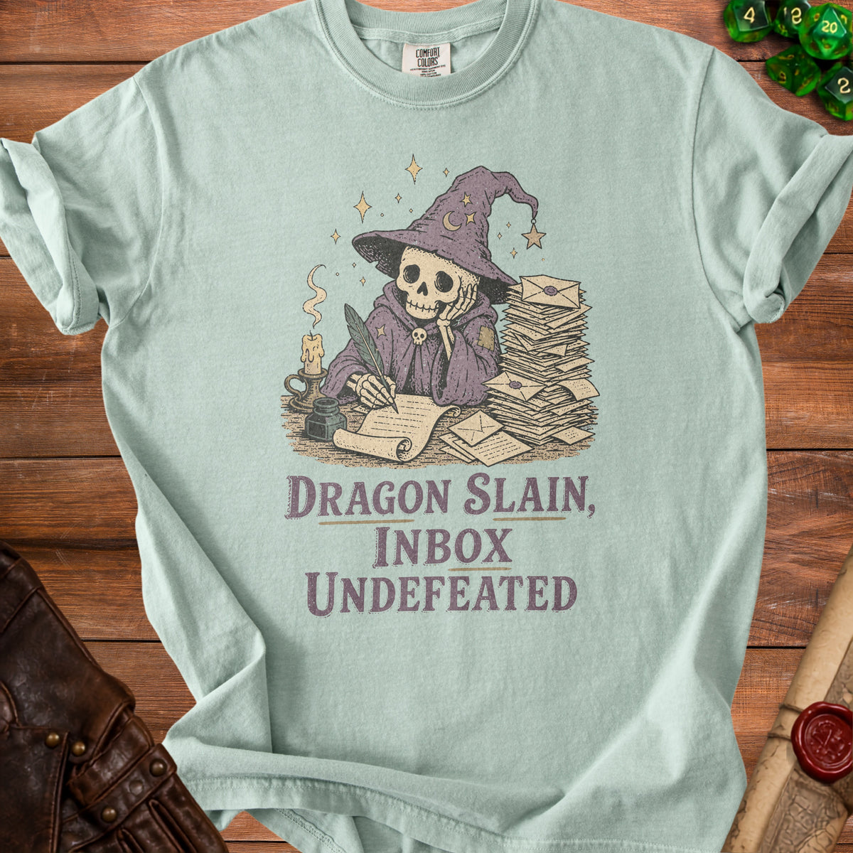T-shirt with skeleton wizard writing, stack of letters, and text "Dragon Slain, Inbox Undefeated".