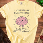 Yellow t-shirt with text "I overthink everything and still get it wrong" and a cartoon brain.