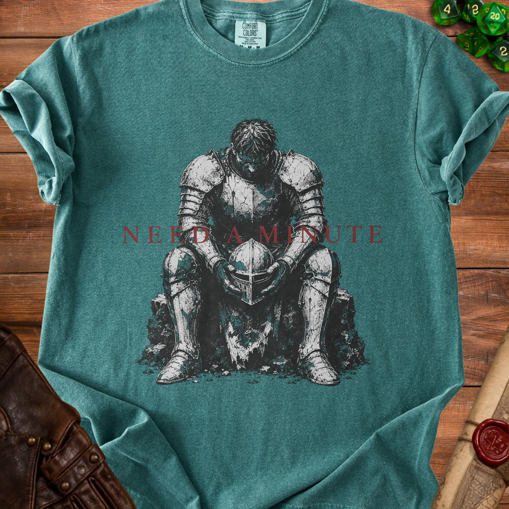 Green t-shirt with a distressed knight holding a helmet and the text "NEED A MINUTE".