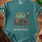 Green t-shirt with a cartoon frog wizard holding a book and staff, text reads "CROAKROMANCER".