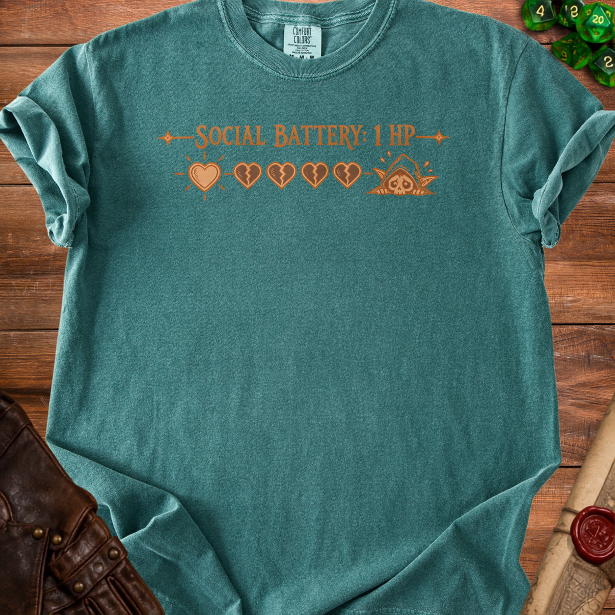 Teal t-shirt with "SOCIAL BATTERY: 1 HP" and game-style health icons.