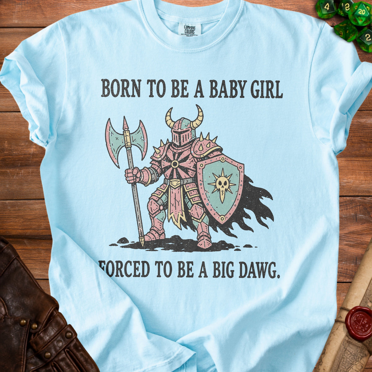 Light blue t-shirt with knight graphic and text "BORN TO BE A BABY GIRL FORCED TO BE A BIG DAWG."