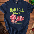 Navy t-shirt with "Bad Roll Club" text, a d20 die, spilled coffee, and a broken cookie.