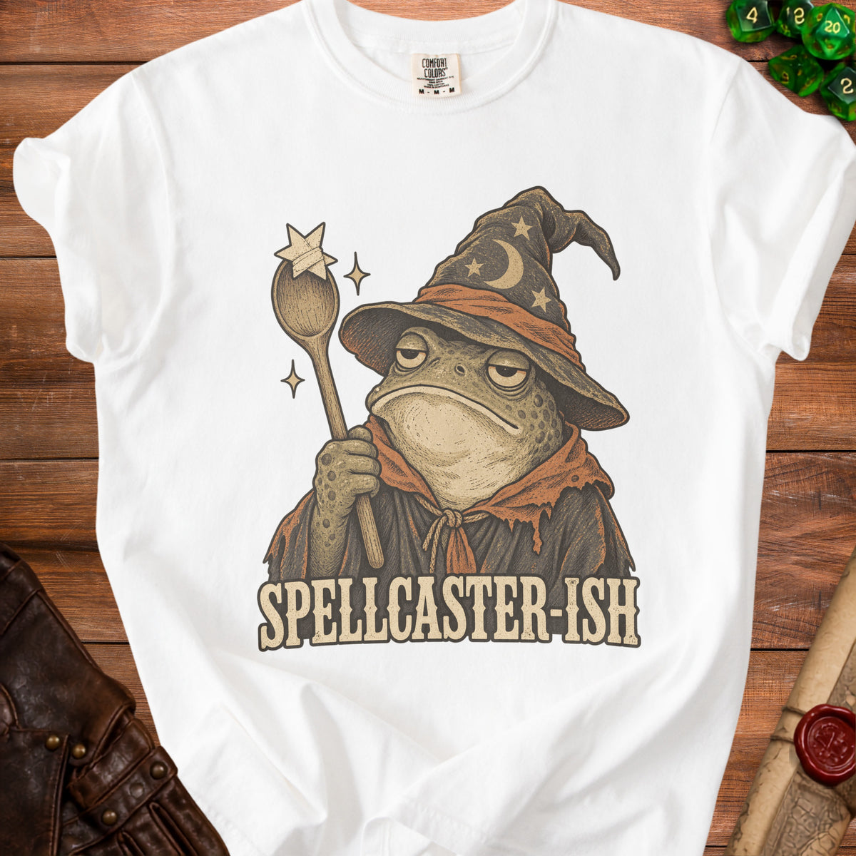 White t-shirt with a frog wizard graphic and the text "SPELLCASTER-ISH".